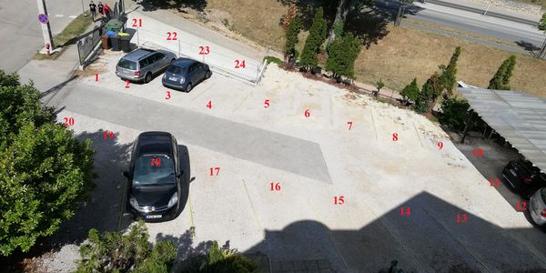 Kamerával megfigyelt udvari parkoló, számozott helyekkel